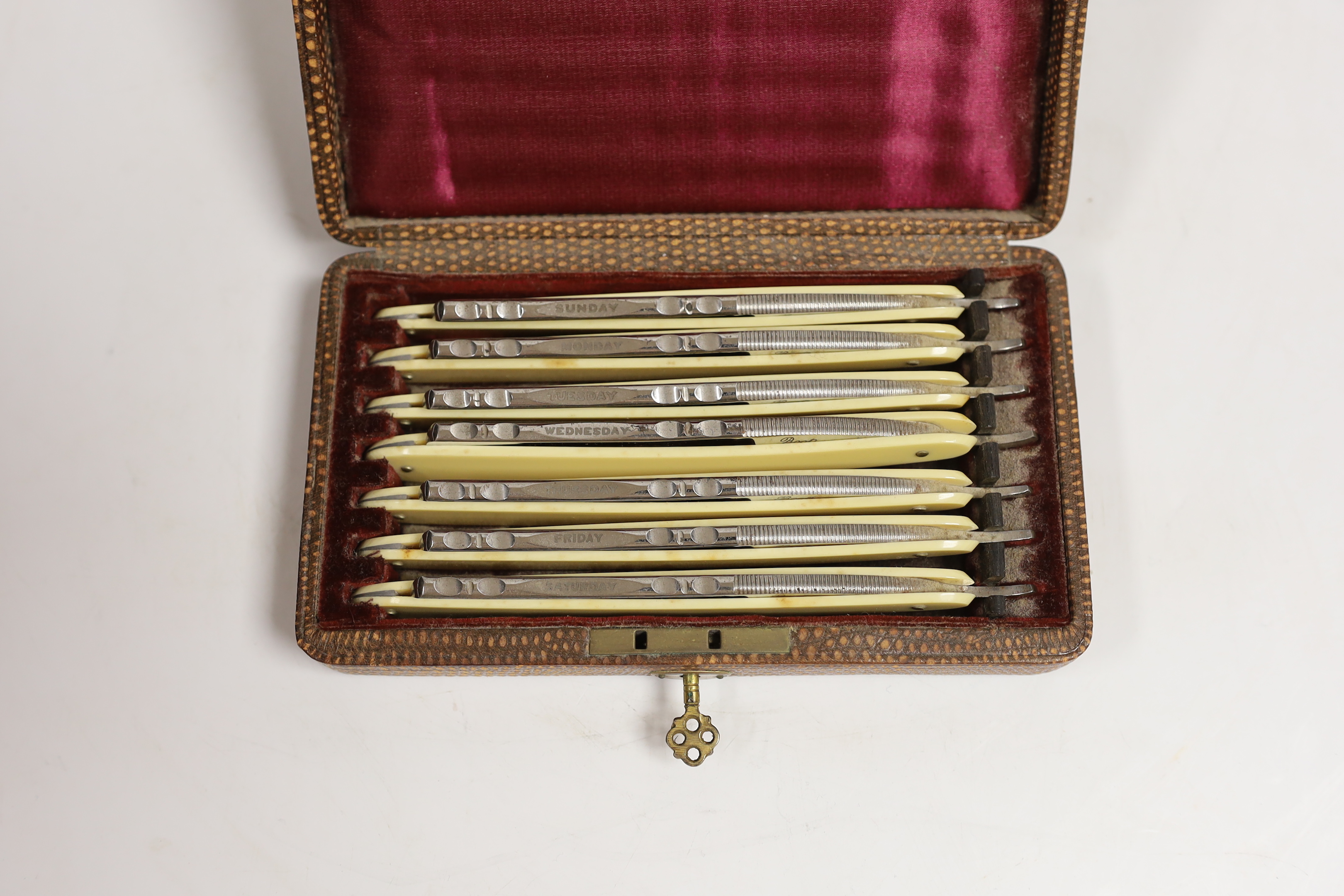 A cased set of cut throat razors, faux ivory handles, Monday - Sunday etched on blades